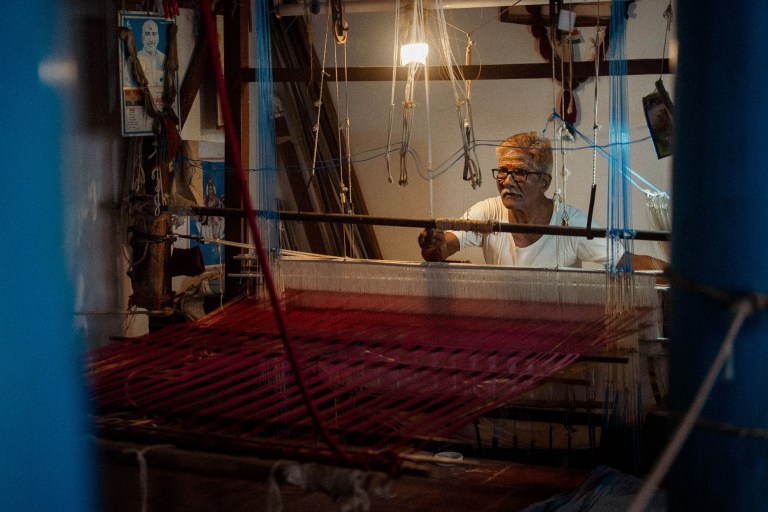 Traditional weaver operating a handloom to create woven fabric in Kerala.